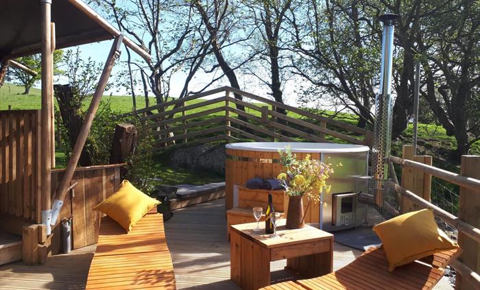 A private wood fired hot tub sits directly outside on the decked veranda.